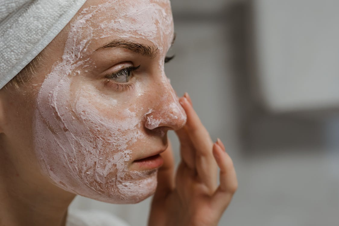 A person applying a cream to their face