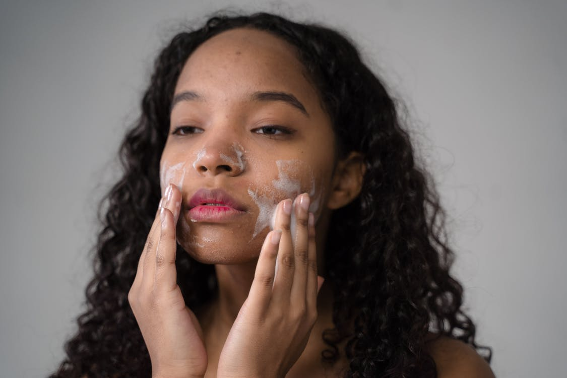 A Woman Rubbing Facial Moisturizing Wash on Her Face